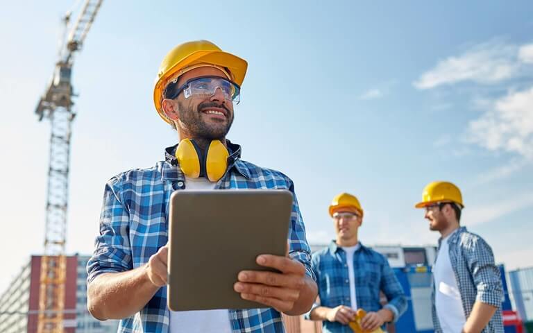 Engineer smiling in front of computer screens