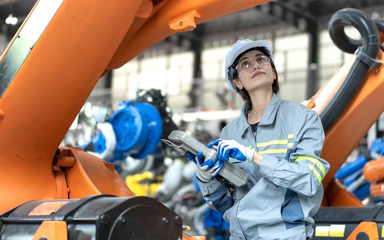 Female industrial engineer maintenance mechanic orange robot frame then assembly to robotic automation machine