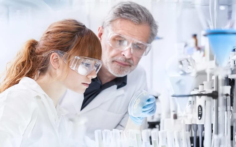 Male and female scientist reviewing equipment