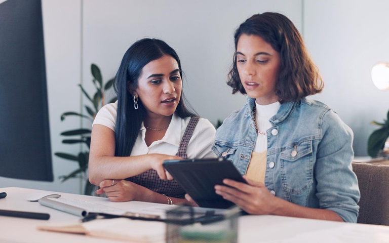 two young women engineers looking in tablet together