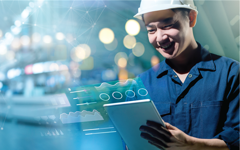 engineer wearing a hardhat smiling in a smart factory machine