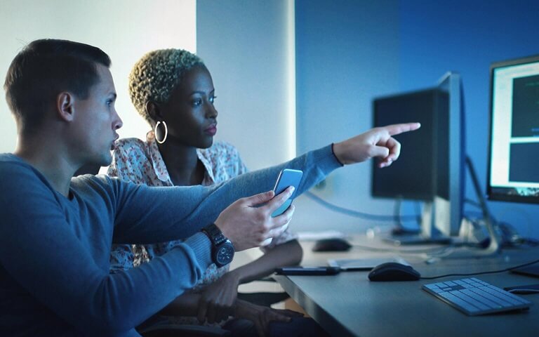 A man and a woman looking at a computer screen