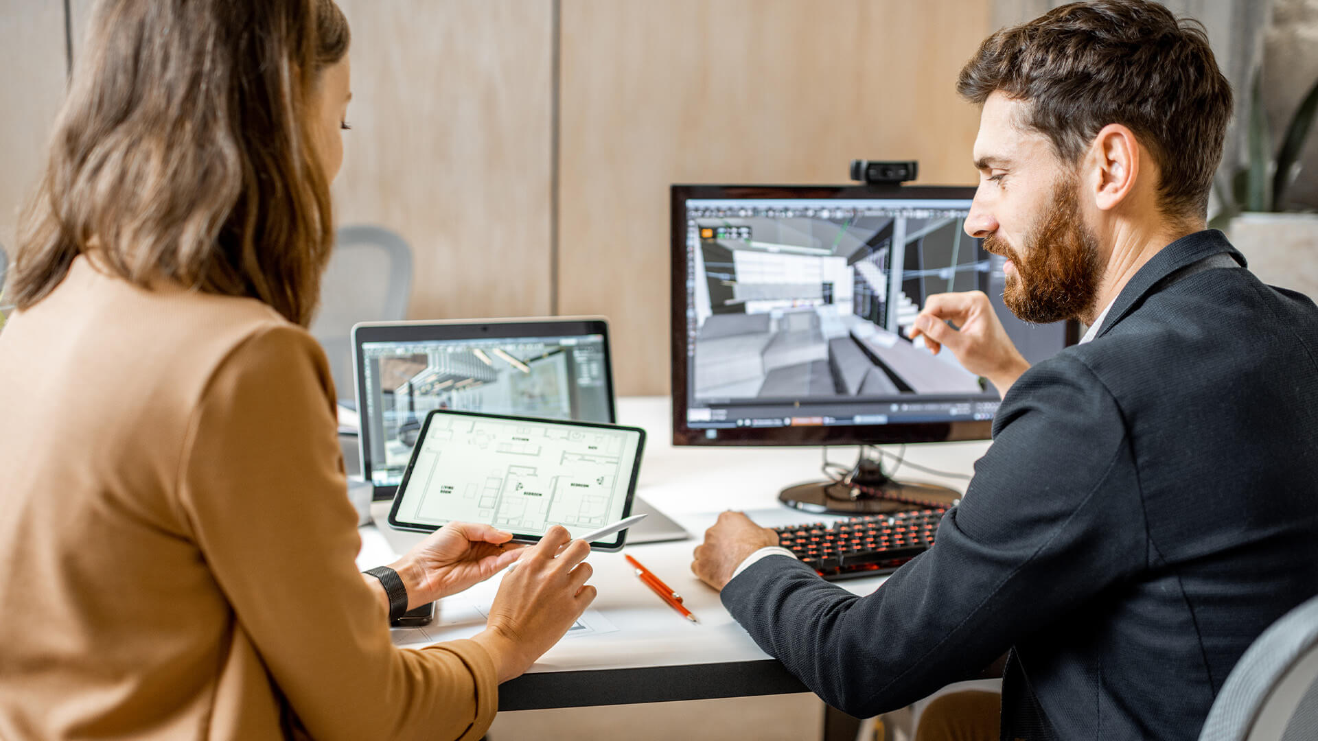 Male and female project architects use Auto Revit, a Building Information Modeling (BIM) software, to steamline and meet project deadlines.