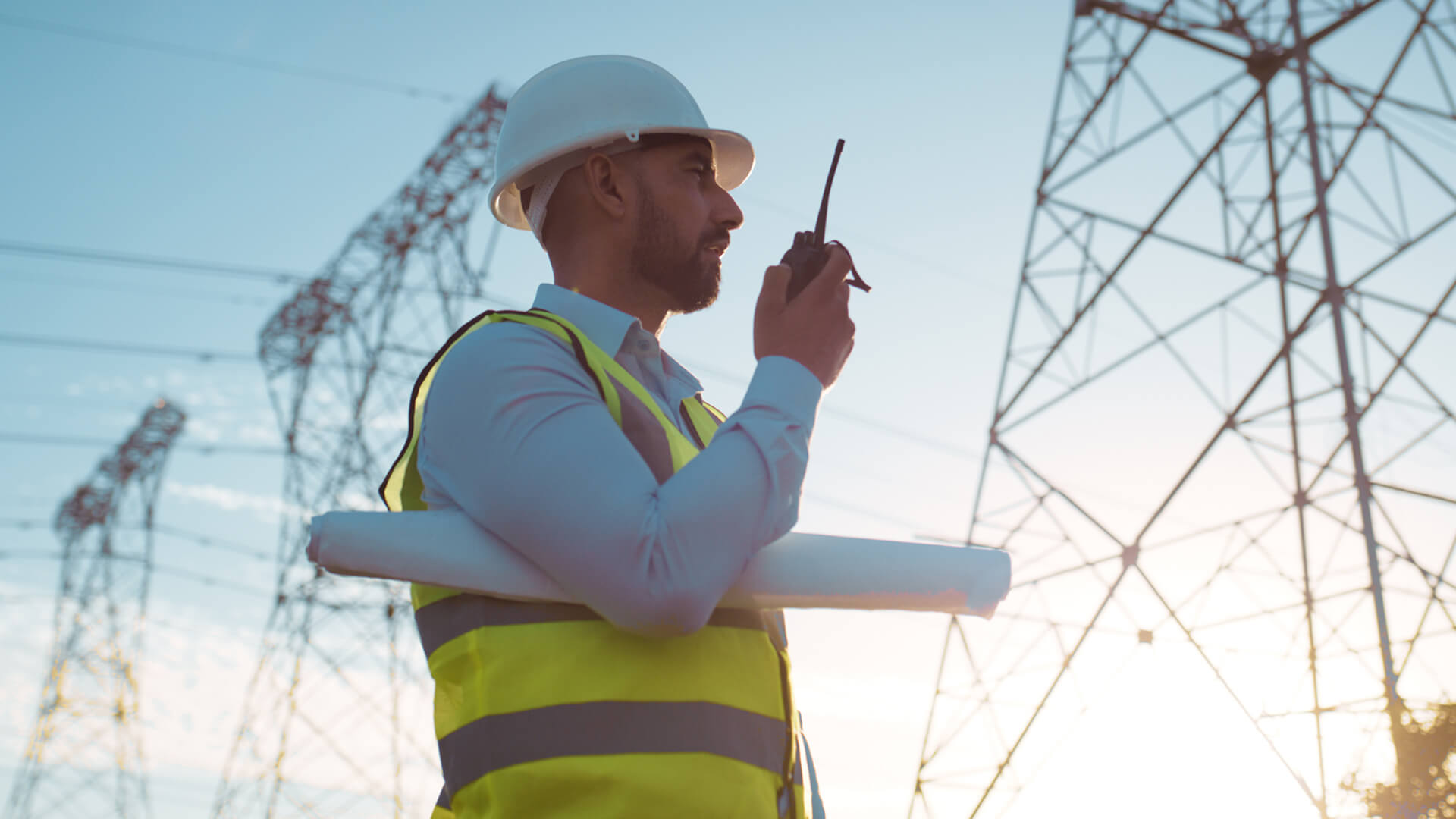 A male program manager for a transmission line project is on-site implementing SOPs and project specific metrics.