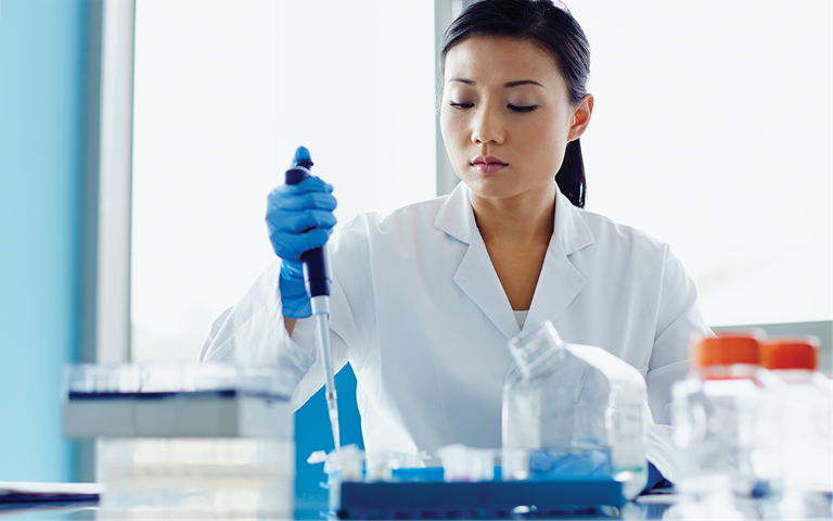  Female scientist using pipette in modern research laboratory