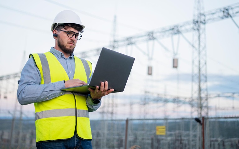 Un ingénieur avec un ordinateur portatif dans l'espace de travail d'une centrale électrique