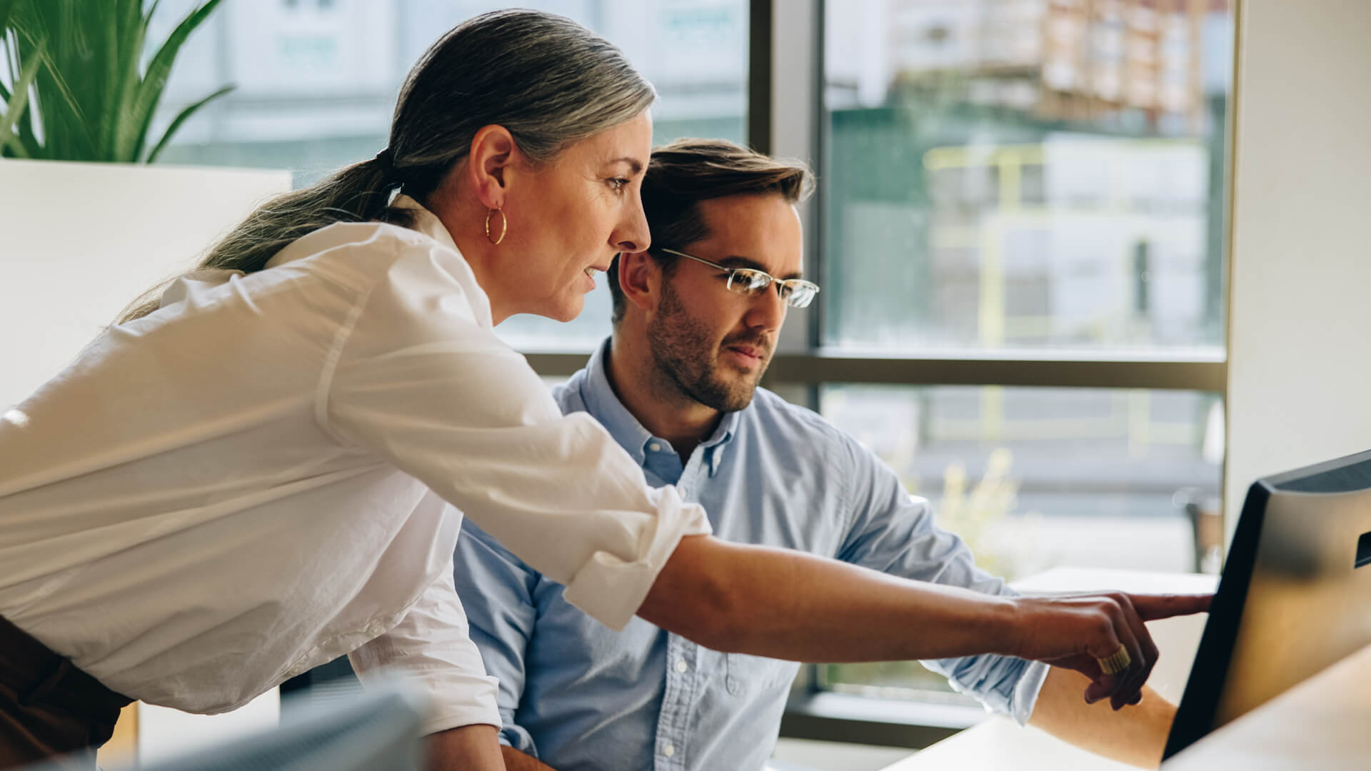 Female and male professionals reviewing the March 2026 jobs report on a desktop looking at February labor market and economy trends.