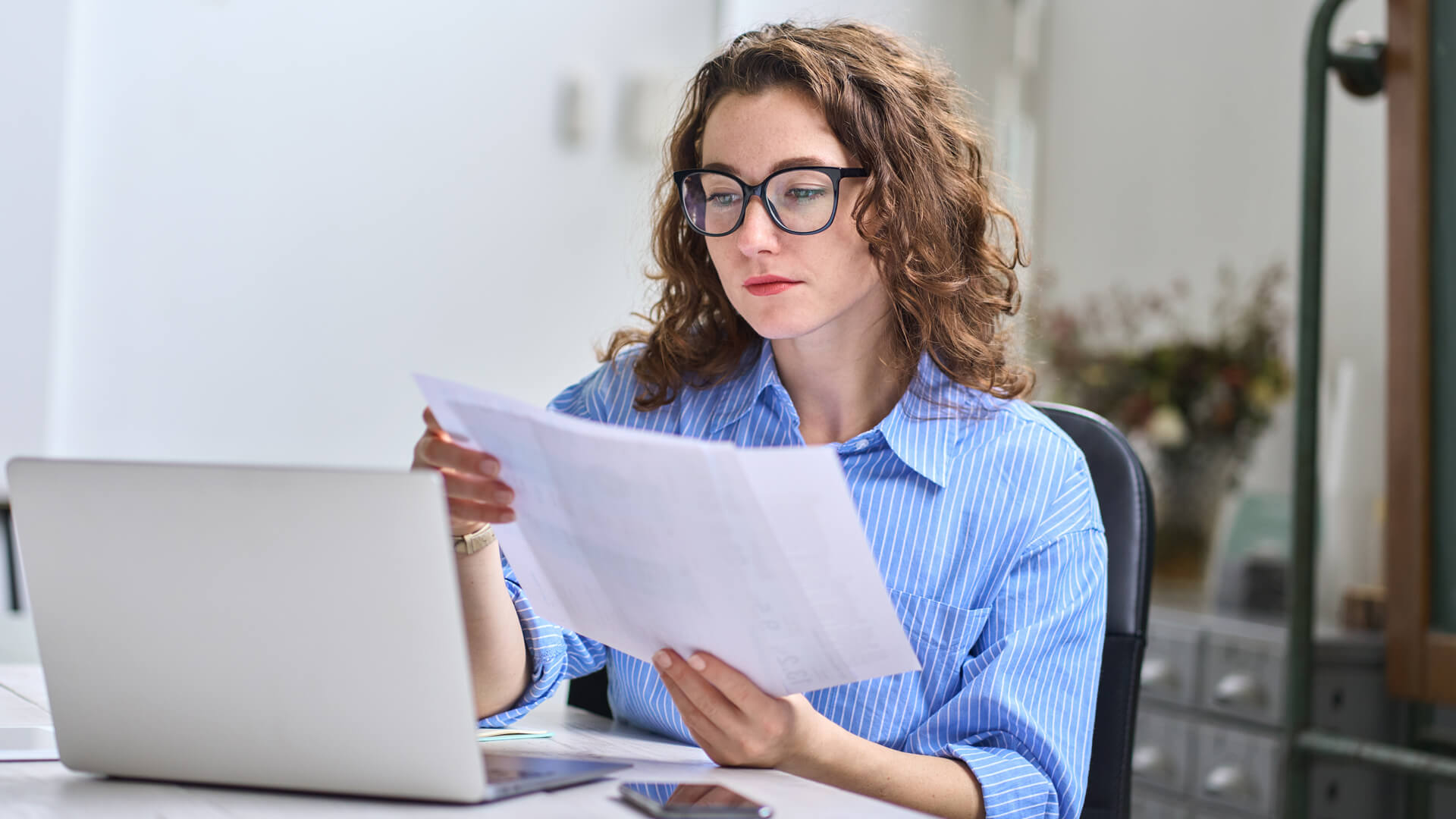 woman at her desk reviewing Actalent's labor market and economy report for March 2025
