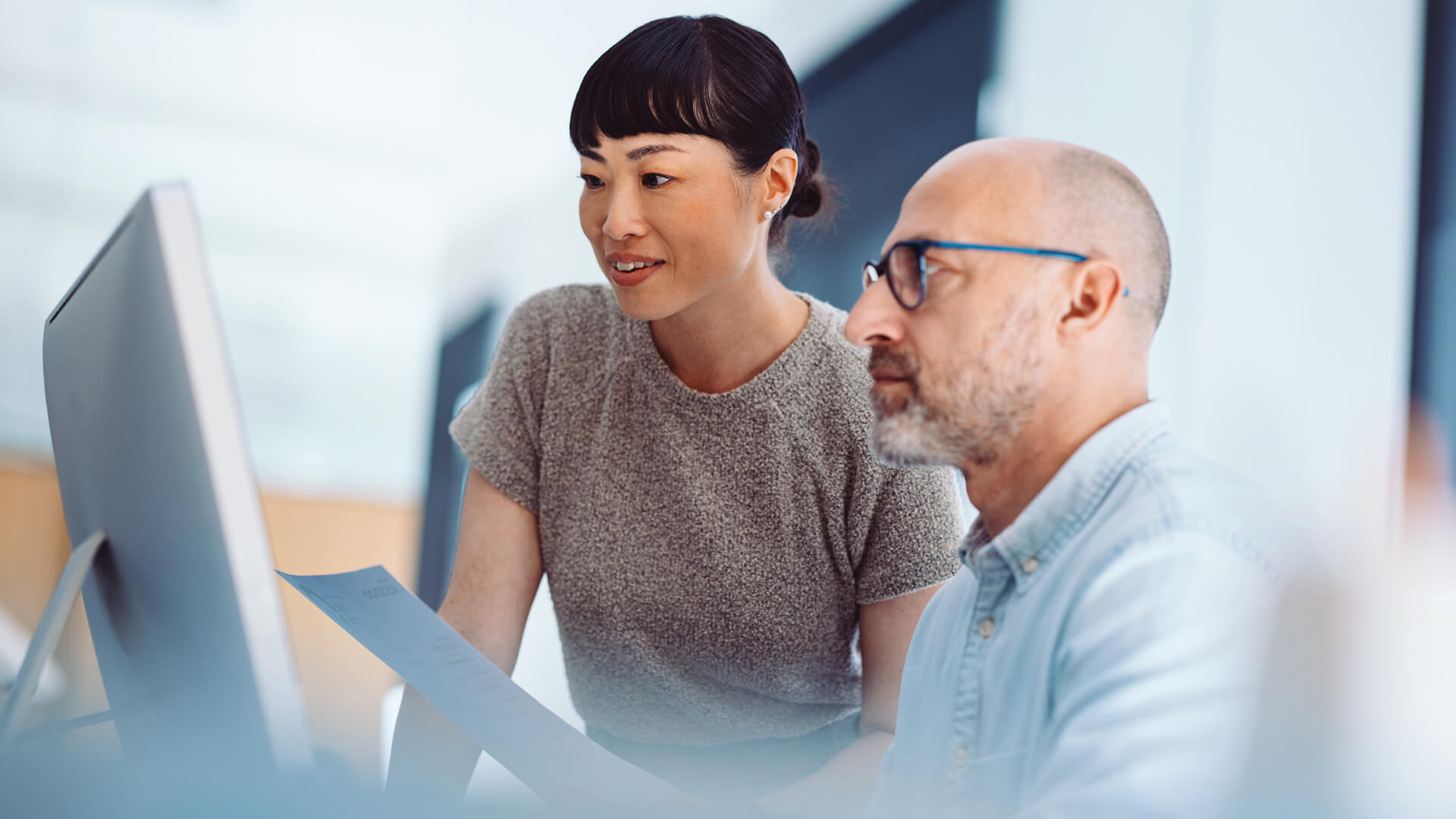 Female and male coworkers reviewing the June 2026 jobs report looking at May labor market and economy trends.