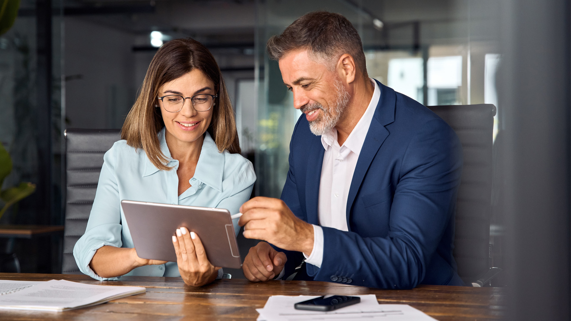 Female and male coworkers reviewing May 2024 jobs report, looking at April labor market trends.