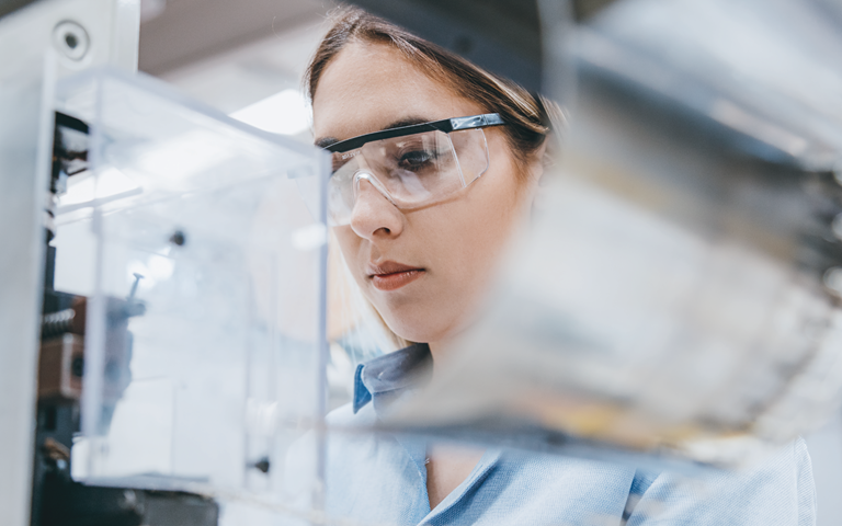 female worker in lab with protective glasses on
