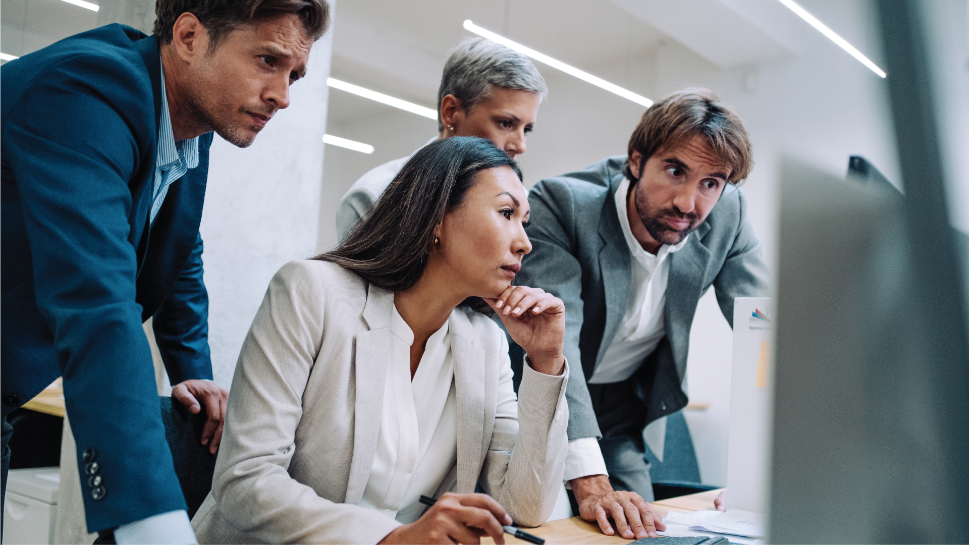 Corporate business people together surrounding computer in office