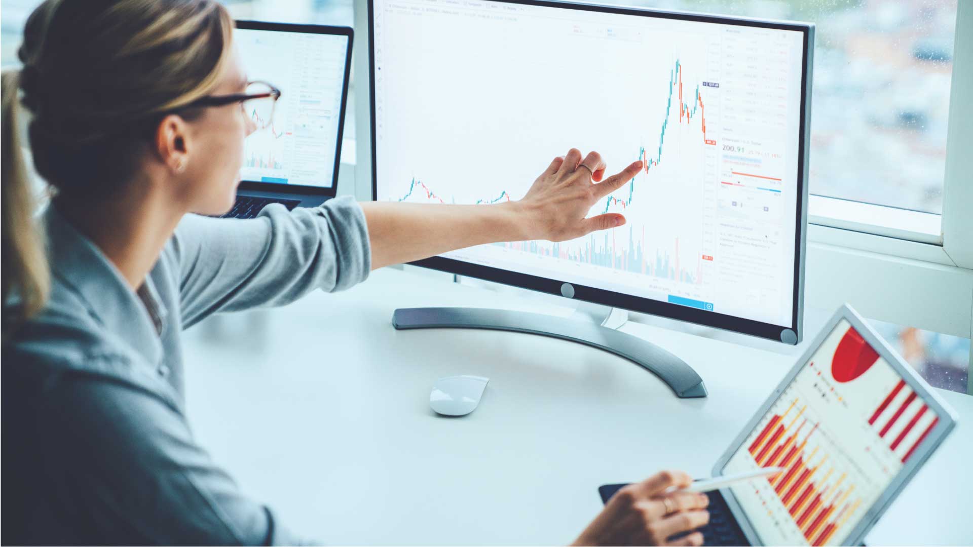 woman pointing at a graph on her computer monitor