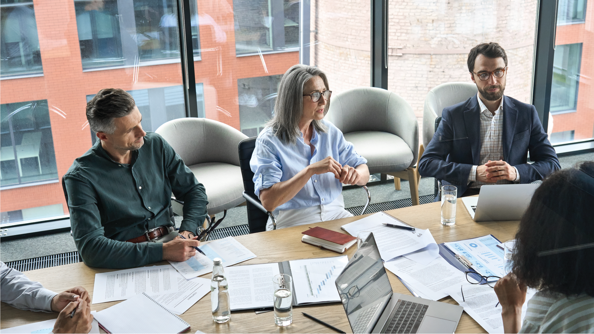 Company managers brainstorm financial plan working together with document papers in office
