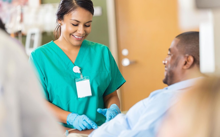 healthcare professional in scrubs smiling with patient